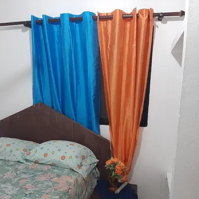 a bedroom with a bed and a blue curtain at B&B KeisyAlba Punta Rucia in Punta Rucia