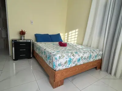 a bedroom with a bed with blue pillows and a table at Apartamentos-Oliver in Las Galeras