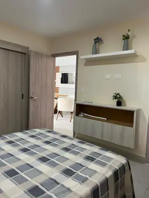 a bedroom with a bed with a blue and white checkered blanket at Villa Medrano