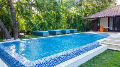 a swimming pool with blue seats next to a house at Chic Villa Pool Casa de Campo in La Romana