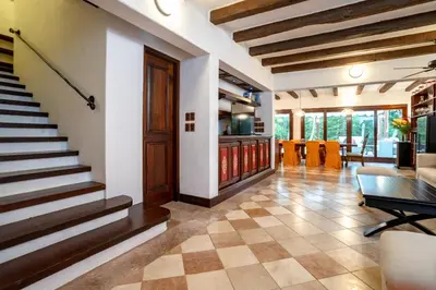 a living room with a staircase and a table at Chic Villa Pool Casa de Campo in La Romana