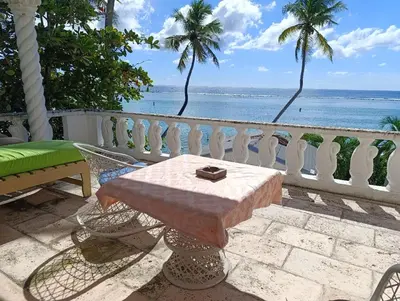 a table on a balcony with a view of the ocean at Hotel Don Michele in Boca Chica