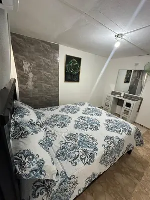 a bedroom with a bed with a blue and white blanket at Residencial JG in Punta Cana