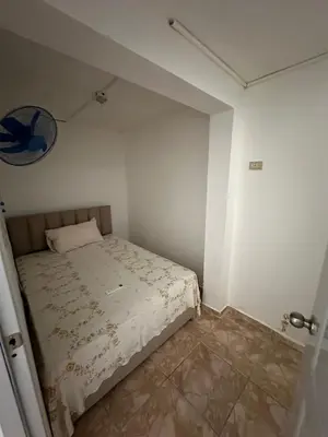 a small white room with a bed in it at Residencial JG in Punta Cana
