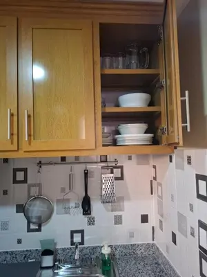 a kitchen with wooden cabinets and a sink with dishes at Las Palmas in Santiago de los Caballeros