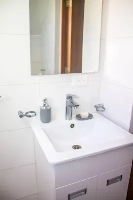 a bathroom with a white sink and a mirror at City Sea Exclusive Colonial Gem with Ocean View in Santo Domingo