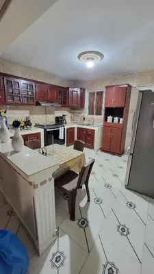 a kitchen with a refrigerator and a table with chairs at Descansa sin prisas a minutos del Aeropuerto in La Caleta