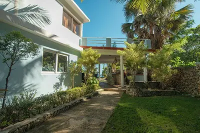 a house with a pathway leading to the front of it at The SeaDog Inn-Oceanfront Villa in Cabrera