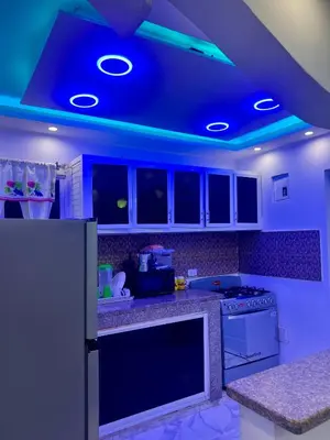 a kitchen with blue lights on the ceiling at Moderna casa cerca de el aeropuerto SDQ y mi rent cars in La Caleta