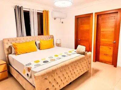 a bedroom with a large bed with yellow pillows at Santiago Amazing 4bedrooms Apt for group, spectacular WIFI, close to all fun in Santiago de los Caballeros