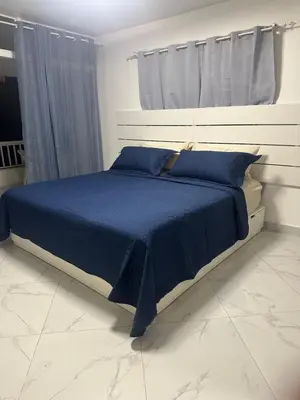 a bedroom with a bed with a blue comforter at Espectacular apartamento IV Albatros byJu Juan Dolió in Villas del Mar