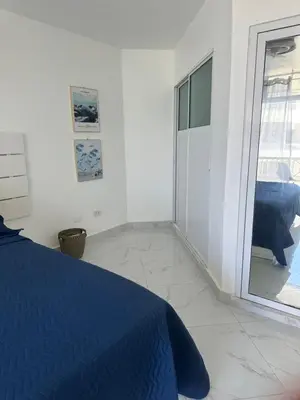 a bedroom with a blue bed and a sliding glass door at Espectacular apartamento IV Albatros byJu Juan Dolió in Villas del Mar