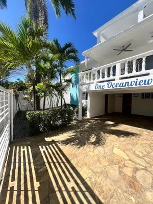 a white house with a one occupancy sign on it at Hermosa villa frente al mar in San Felipe de Puerto Plata