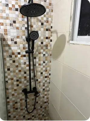 a shower in a bathroom with a tiled wall at Lujoso apartamento cerca del aeropuerto SDQ in La Caleta