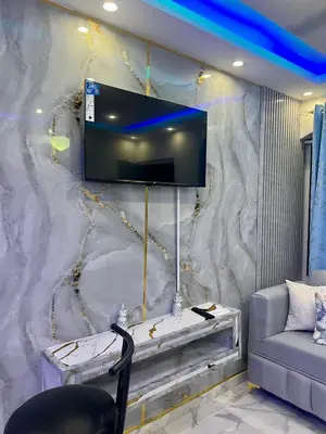 a living room with a tv on a marble wall at Lujoso apartamento cerca del aeropuerto SDQ in La Caleta
