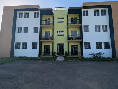 an apartment building with white and yellow at Elegant apartment within a gated residential complex- 10 mins from Cabarete in Gaspar Hernández