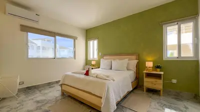 a bedroom with a bed and two windows at Oceanfront Escondido Bay Laguna Beach in Sosúa