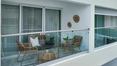 a balcony with chairs and a table on it at Oceanfront Escondido Bay Laguna Beach in Sosúa