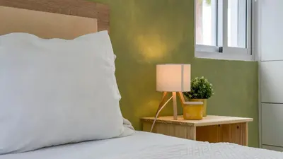 a bed with a white pillow and a lamp on a table at Oceanfront Escondido Bay Laguna Beach in Sosúa