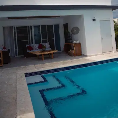 a swimming pool in a living room next to a house at Caribbean getaway Villa 30 in Puerto Plata