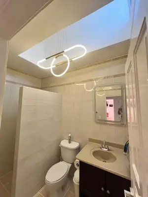 a bathroom with a toilet and a sink and a light at Paraiso frente al mar in San Felipe de Puerto Plata