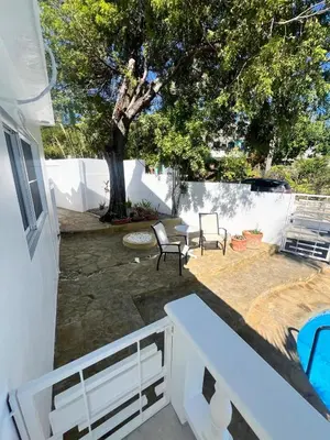 a patio with two chairs and a table and a tree at Paraiso frente al mar in San Felipe de Puerto Plata