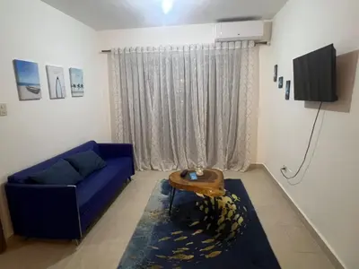 a living room with a blue couch and a table at Antares II in San Isidro