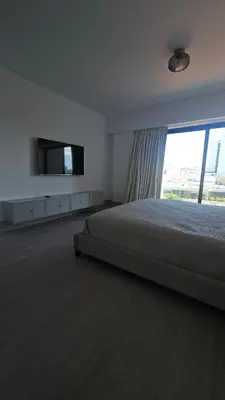 a bedroom with a bed and a flat screen tv at Luxury 2-Bed Condo in Piantini Sauna, Gym, & Pool in Santo Domingo