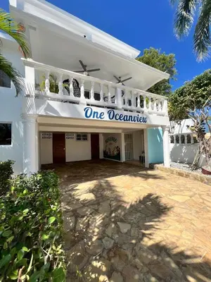 a white building with a one reservation sign on it at ocean view tropical in Maggiolo