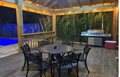 a patio with a table and chairs and a grill at Luxury Villa in Muñoz, Puerto Plata in Puerto Plata