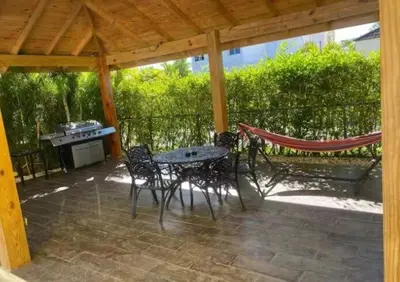 a patio with a table and chairs and a hammock at Luxury Villa in Muñoz, Puerto Plata in Puerto Plata