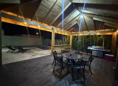 a patio with a table and chairs and a grill at Luxury Villa in Muñoz, Puerto Plata in Puerto Plata