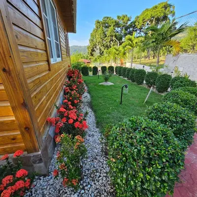 a garden with flowers next to a house at Villa Monte Alba in San Felipe de Puerto Plata