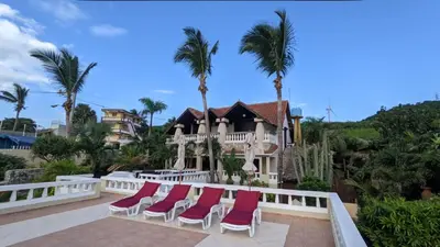 a group of chairs sitting on a balcony in front of a house at Ecolodge Vistamar in Los Patos