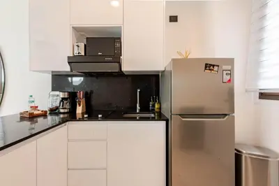 a kitchen with white cabinets and a stainless steel refrigerator at Cana Rock Universe in Punta Cana