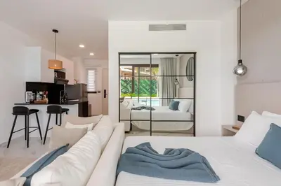 a living room with a white couch and a kitchen at Cana Rock Universe in Punta Cana