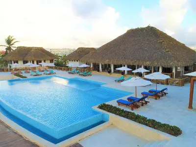 a pool at a resort with chairs and umbrellas at Cana Rock Universe in Punta Cana