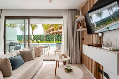 a living room with a white couch and a tv at Cana Rock Universe in Punta Cana