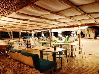 a restaurant with tables and chairs and people in the background at Palmar Apartments Comfort Great Location in Punta Cana