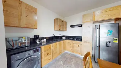 a kitchen with wooden cabinets and a stainless steel refrigerator at Palmar Apartments Comfort Great Location in Punta Cana