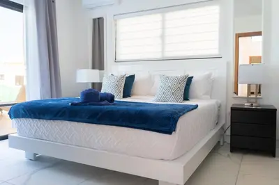 a bedroom with a bed with a blue blanket on it at Newly Built Luxury Private 3 Bedroom Pool Villa in Sosúa