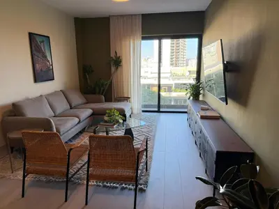 a living room with a couch and a table and chairs at Luxury 2-Bed Condo in Piantini Sauna, Gym, and Pool in Santo Domingo