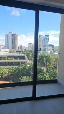 a room with a view of a city from a window at Luxury 2-Bed Condo in Piantini Sauna, Gym, and Pool in Santo Domingo