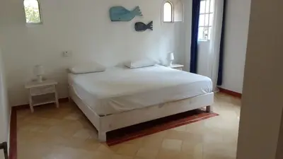 a bedroom with a white bed with two night stands at Rose&mary in Las Terrenas