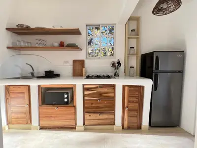 a kitchen with wooden cabinets and a refrigerator at Rose&mary in Las Terrenas