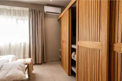 a bedroom with a bed and a large wooden cabinet at New* 3BR Loft | Pool | Patio | 2 mins to Beach in Las Terrenas