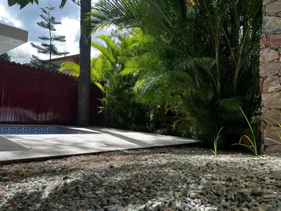 a garden with a sidewalk and a fence and trees at Villa Orquidea in Buena Vista