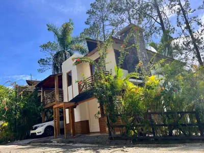 a house with a car parked in front of it at Villa Orquidea in Buena Vista