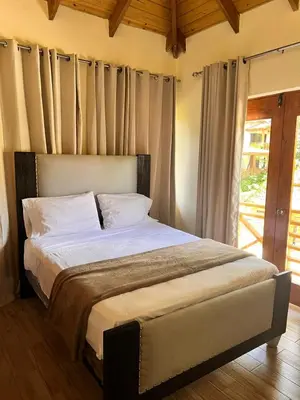 a bedroom with a large bed with white sheets at Villa Orquidea in Buena Vista
