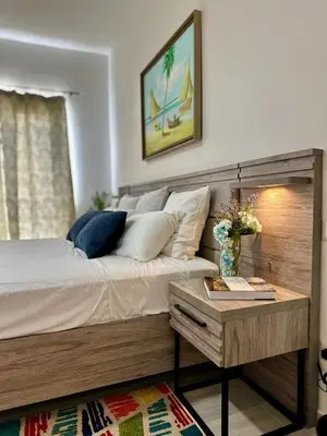 a bedroom with a large bed and a table at Corner 2BDR in Coral Bay 2 in front of Hard Rock in Punta Cana